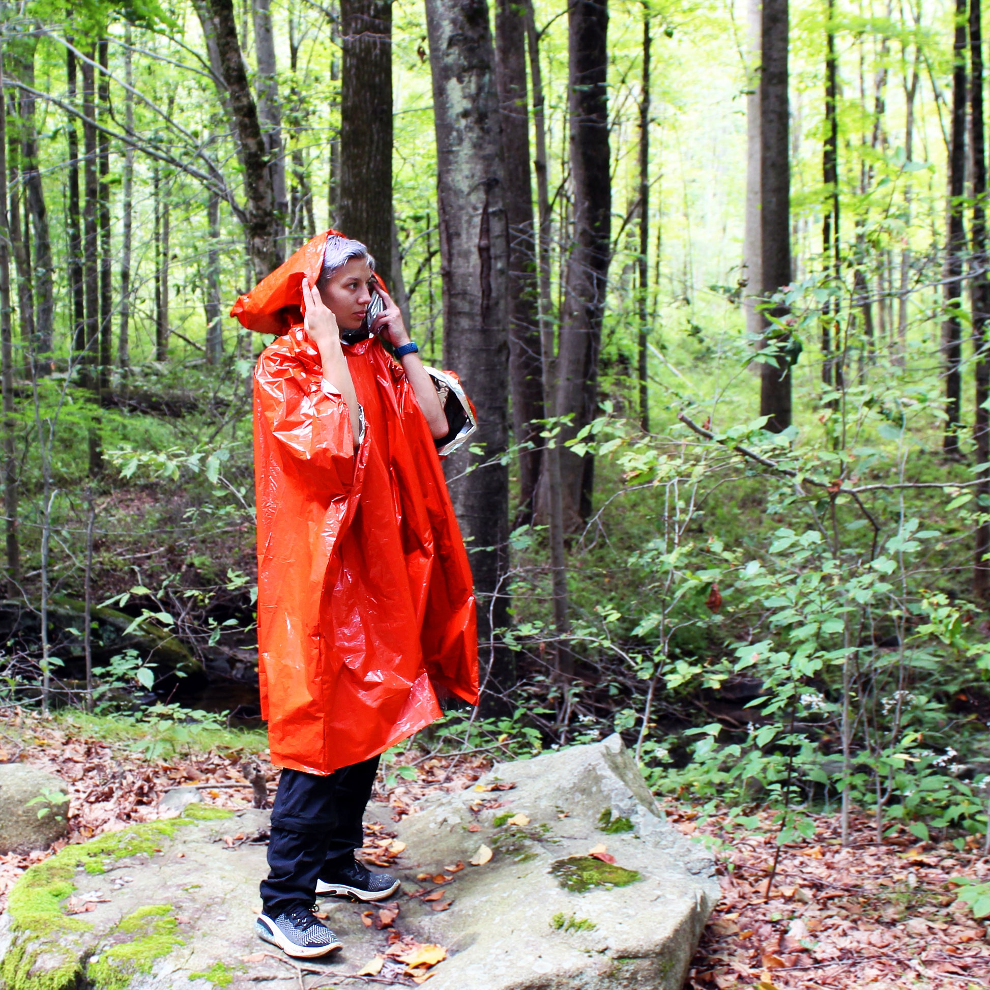Another person wearing Emergency Mylar Poncho in woods