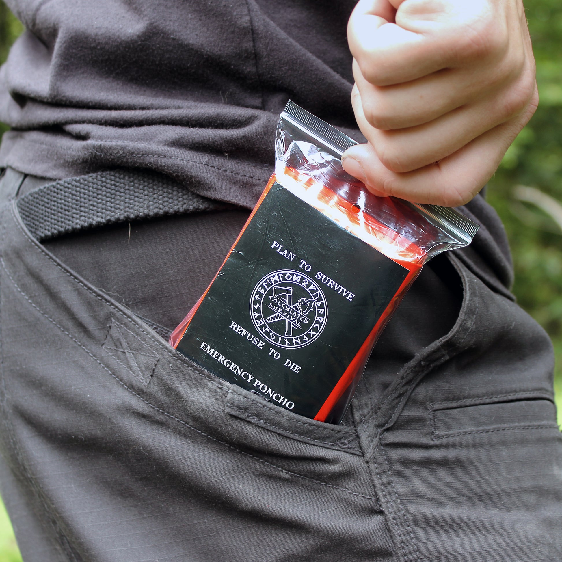 Person putting Emergency Mylar Poncho in pants pocket