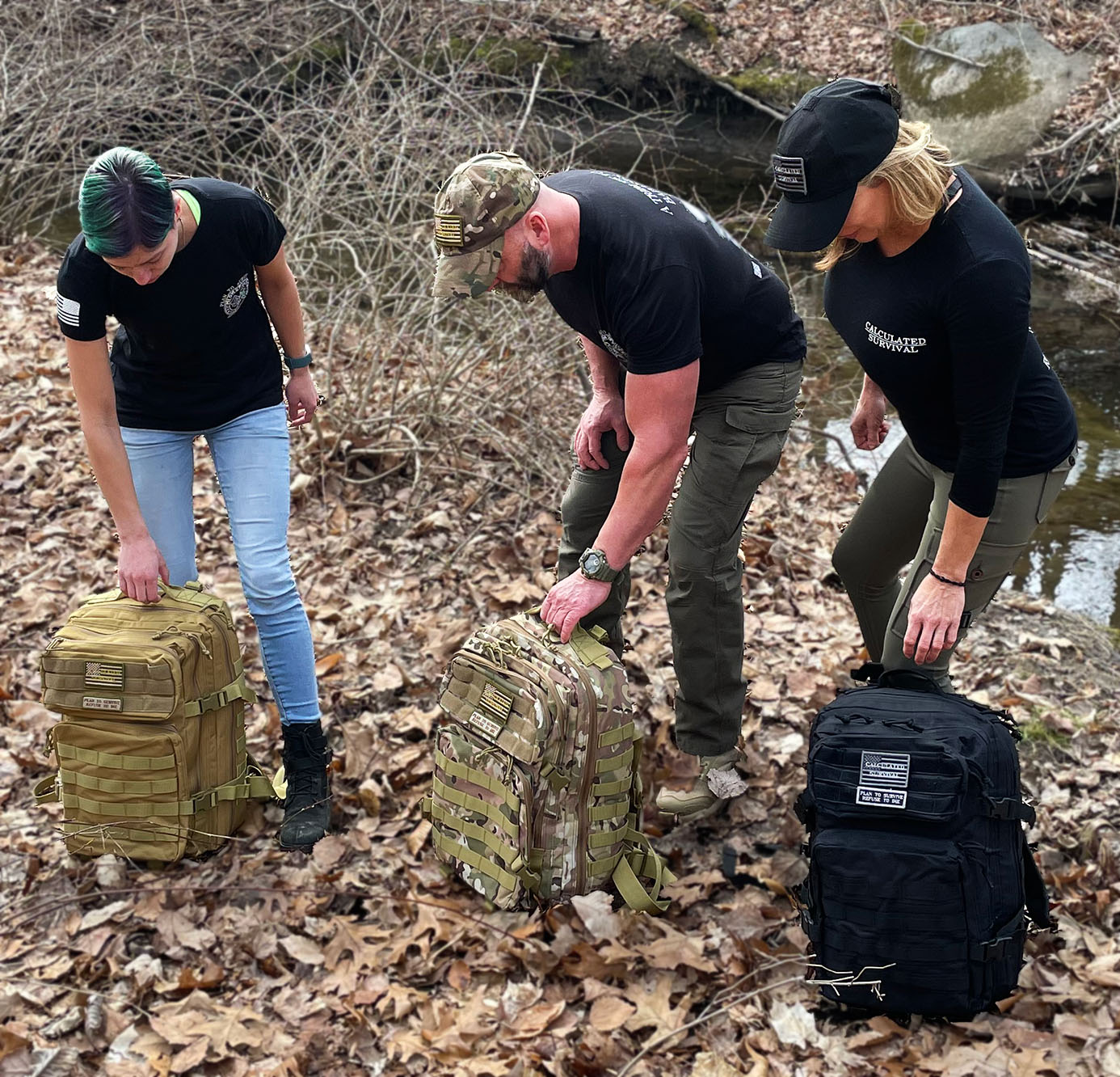 3 people placing Ruck Sacks on Ground